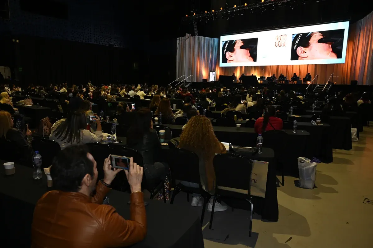 Sala principal con asistentes frente a las pantallas